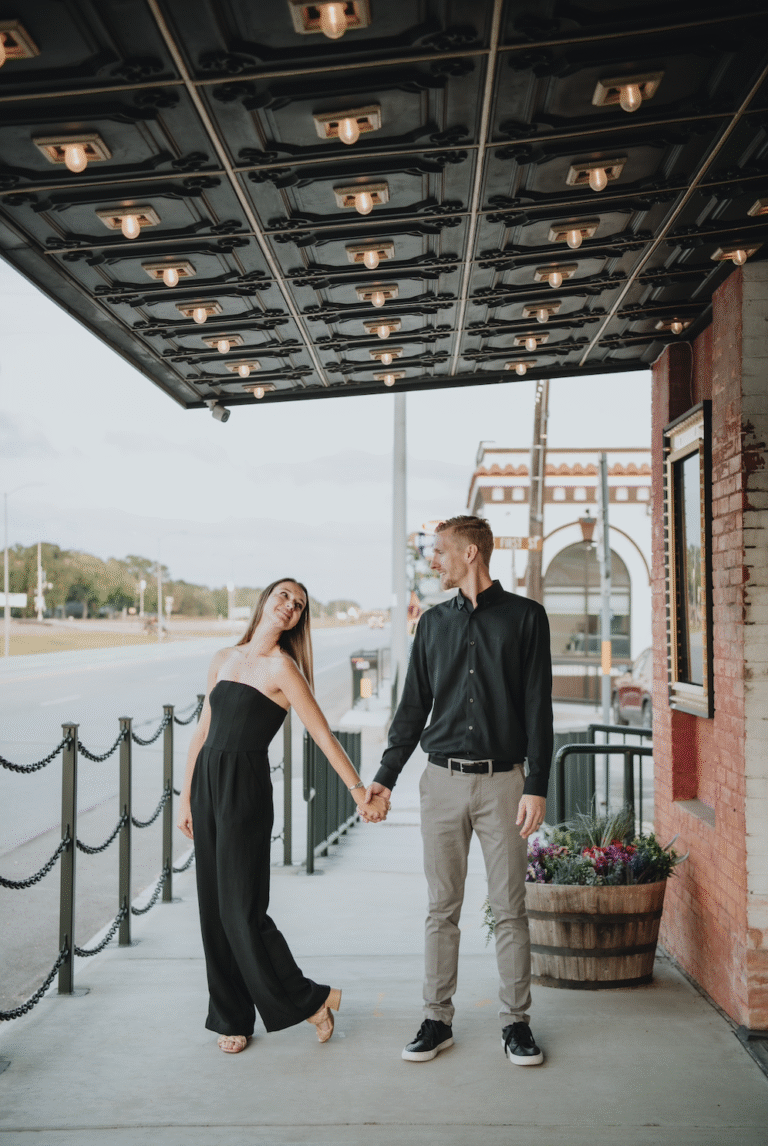 couple dancing in front of historic theatre entrance building in old town texas